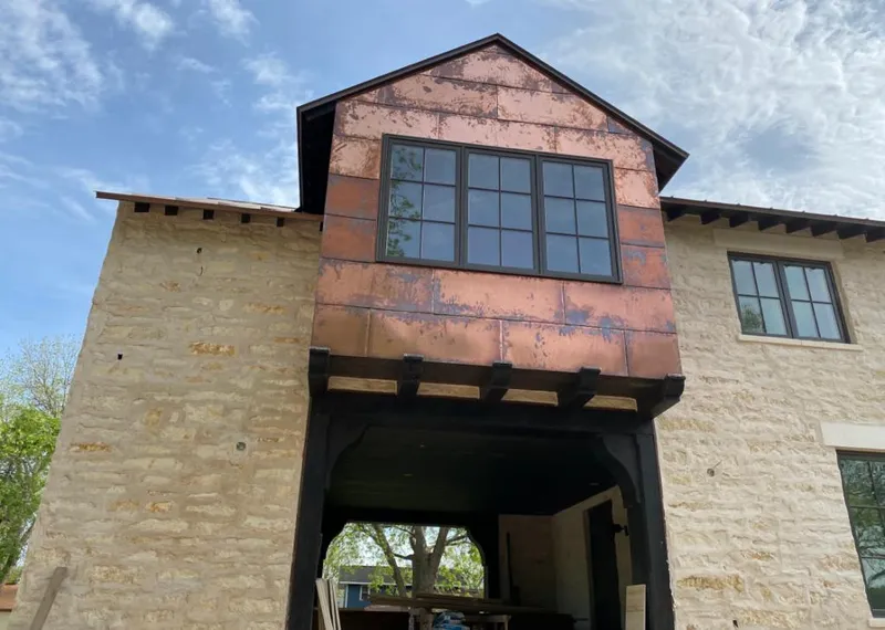Copper metal panel facade on a stone building for Roof Repair in Holly Springs